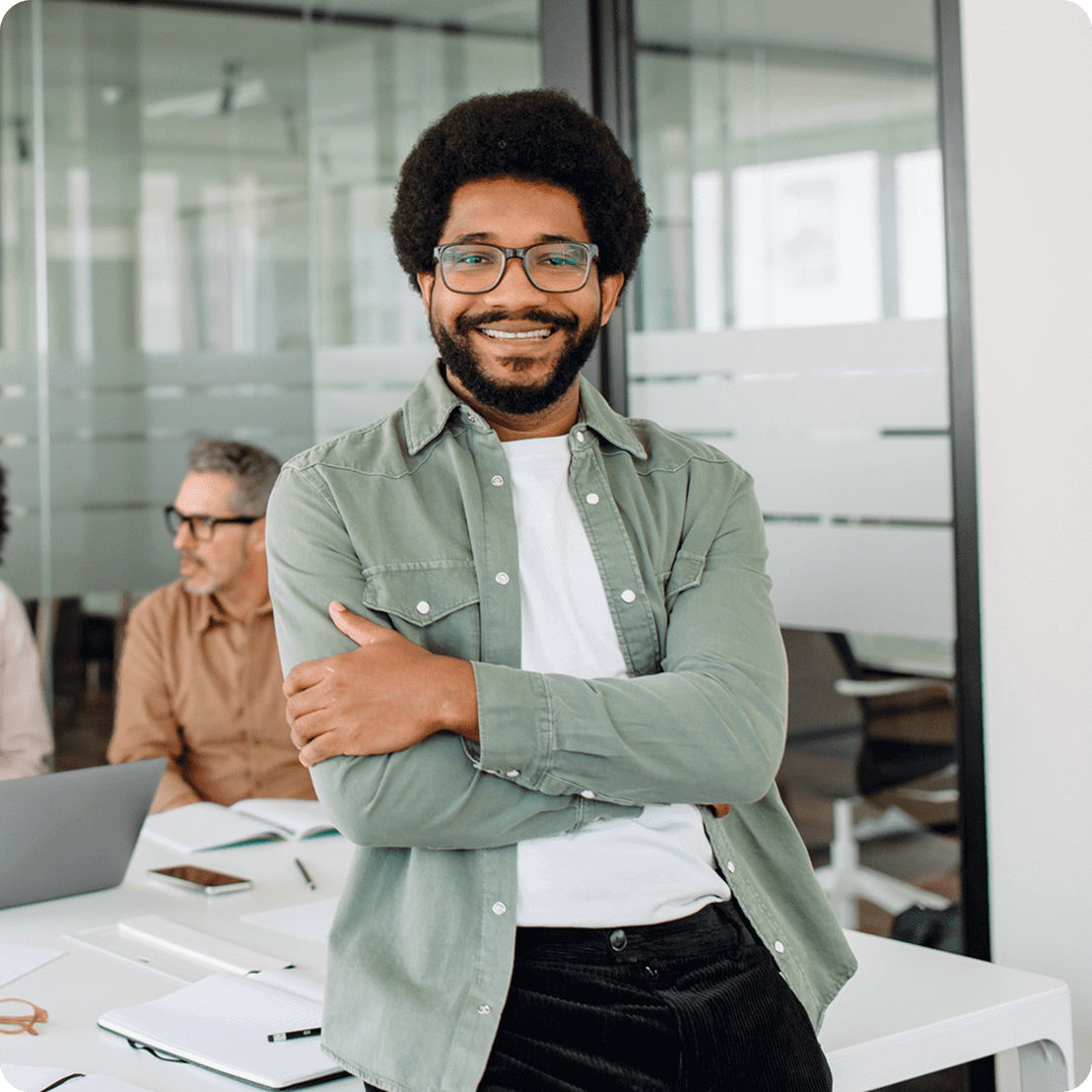 Smiling man in office with colleagues working.