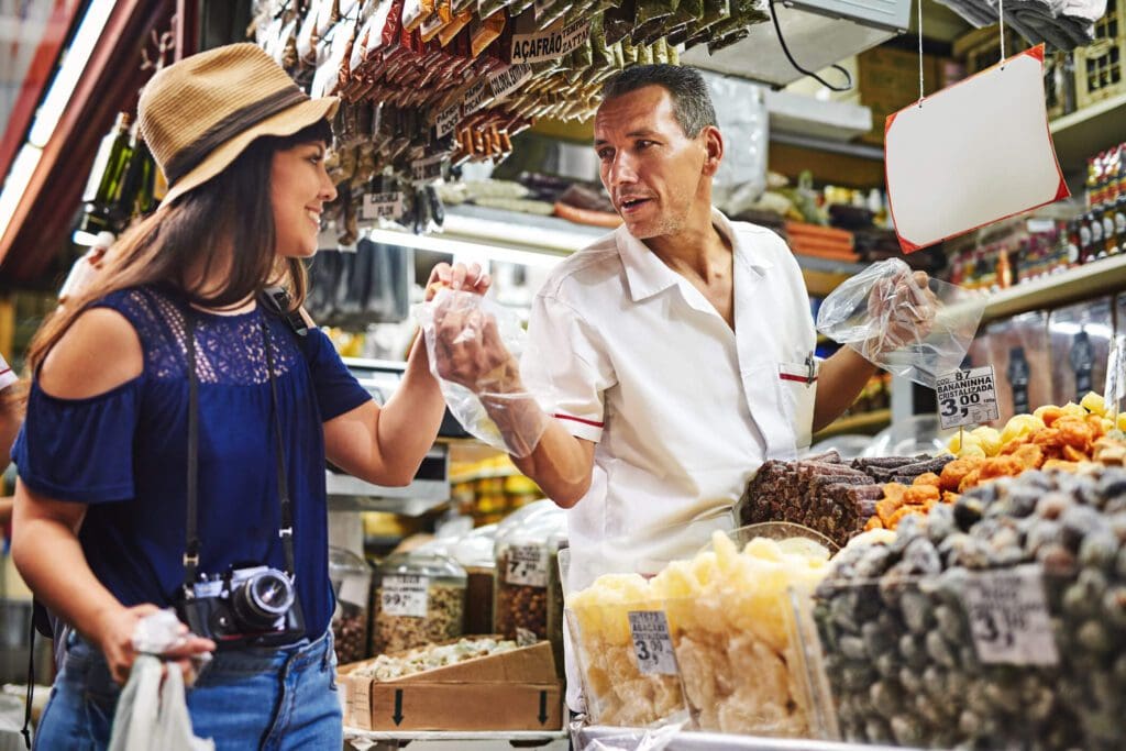 Couple shopping and enjoying dried goods at a market stall.