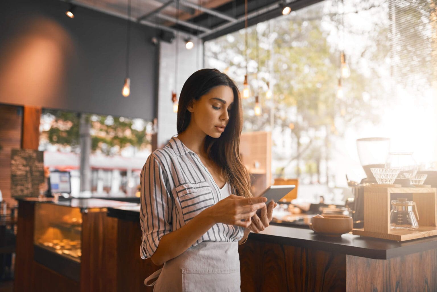 A woman focused on her phone in a cozy cafe.