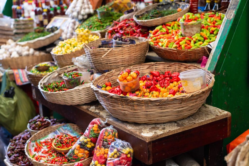 Colorful baskets of various fresh chilies displayed at a market.