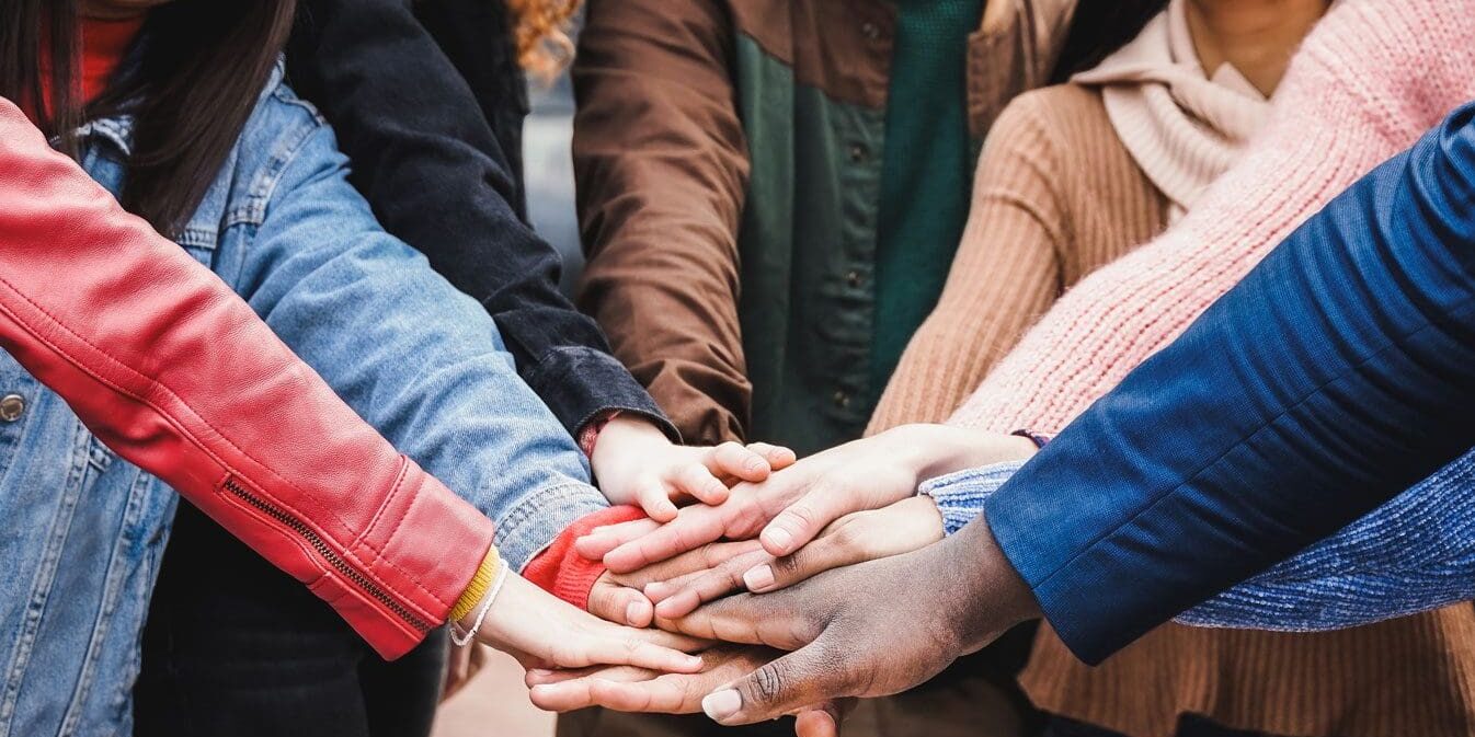 A group of people joining hands in unity.